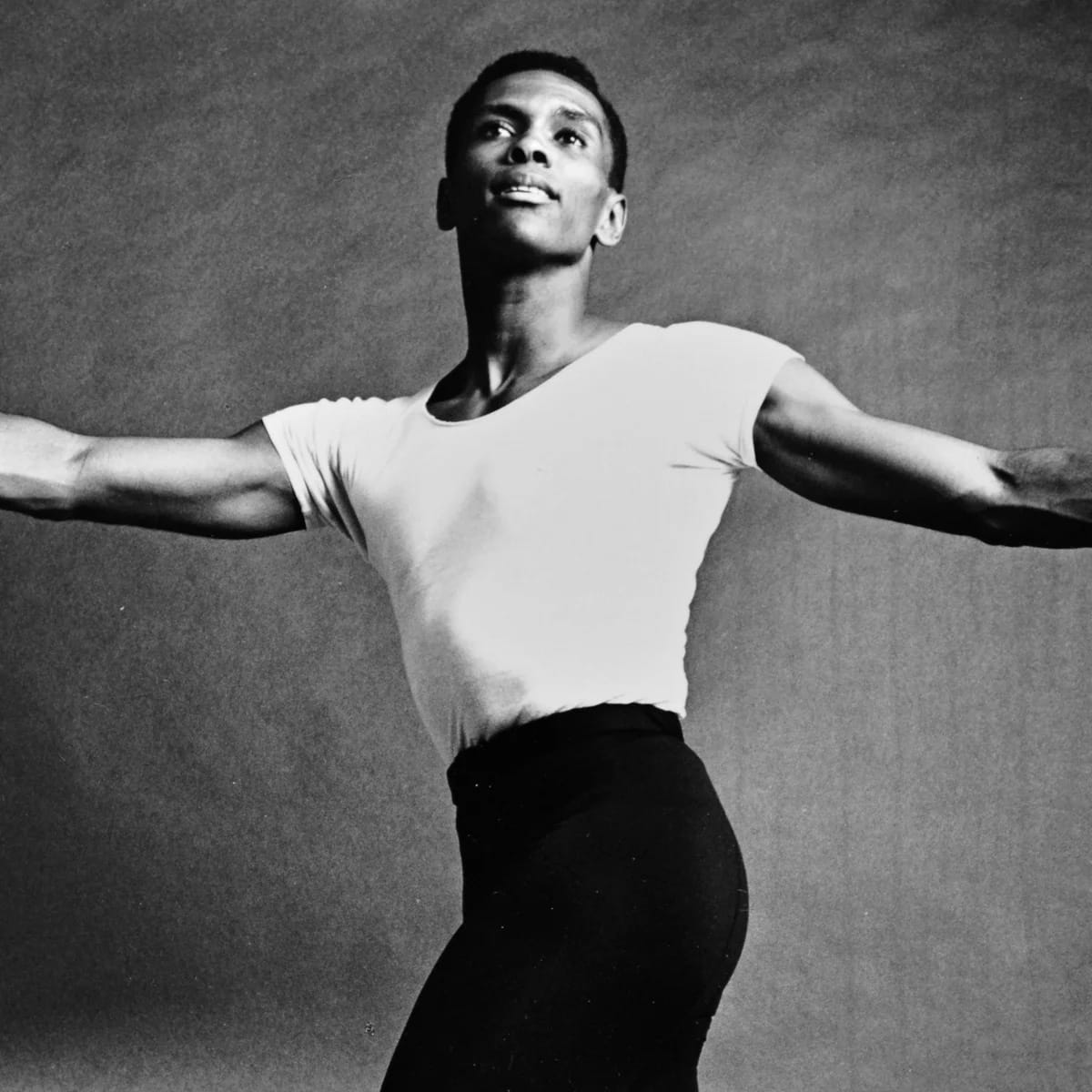 a black and white photo of the legendary dancer Arthur Mitchell mid dance