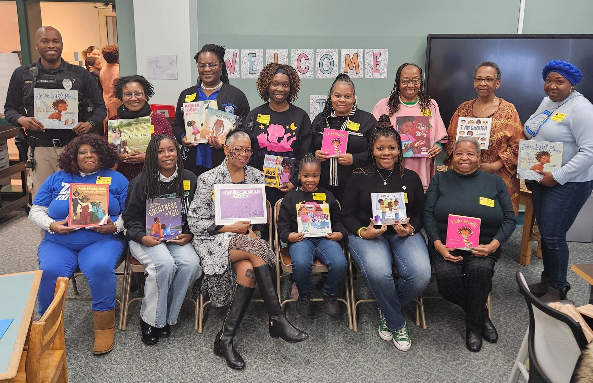 A group of Black adults hold picture books and pose together for the 2025 African American Read In.