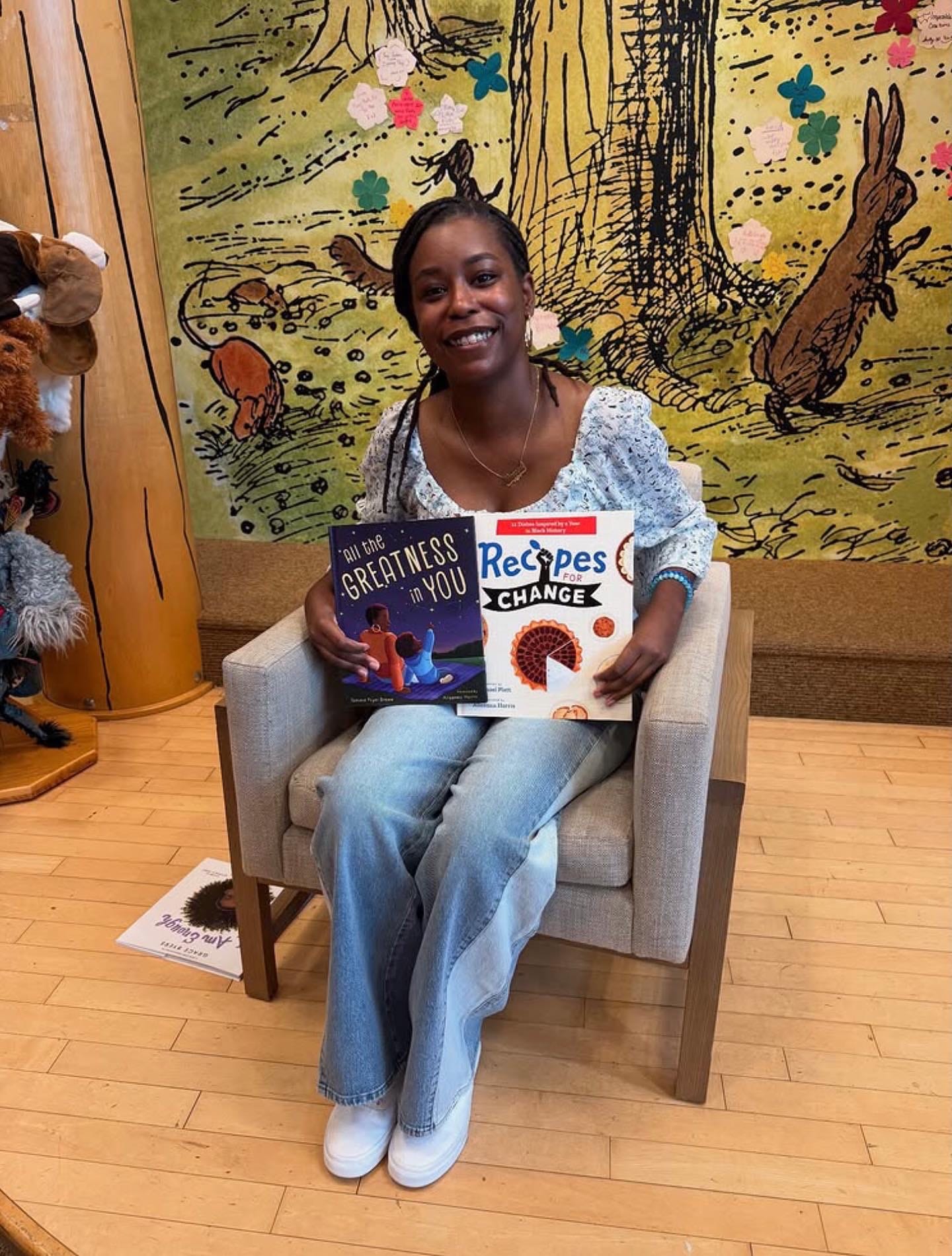 Alleanna Harris poses with two of her picture book picks: All the Greatness in You and Recipes for Change.