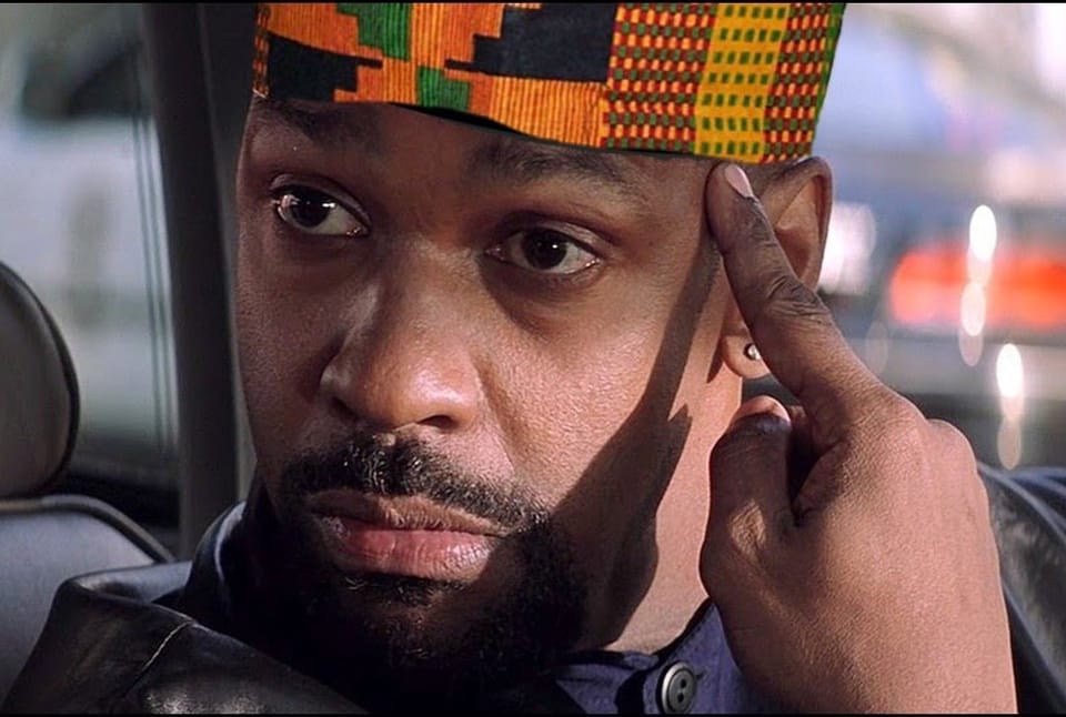 Denzel Washington points to his kente kufi.